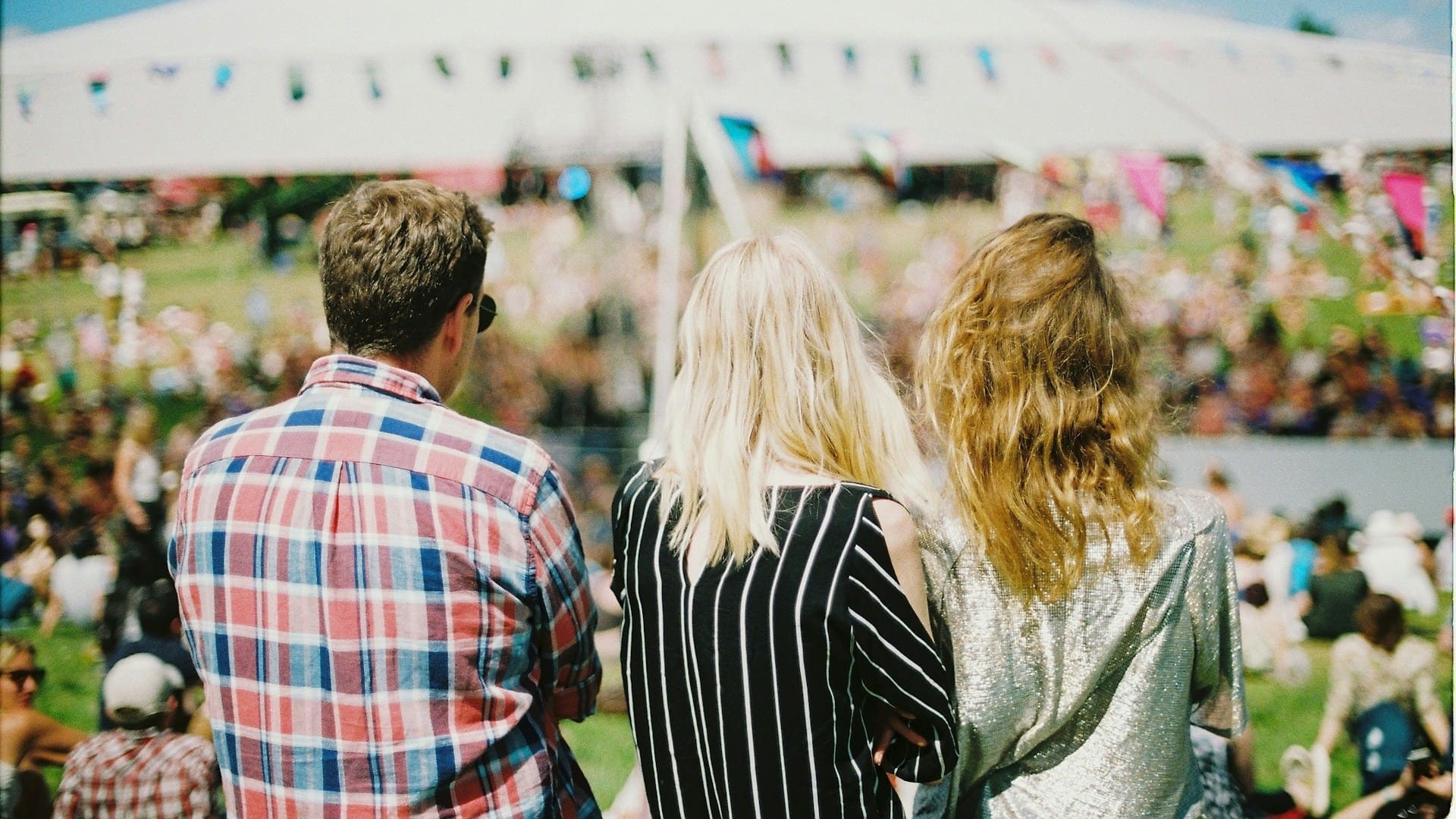 Bezoekers op grasveld kijken naar podium tijdens festival, een creatief voorbeeld van evenement organiseren