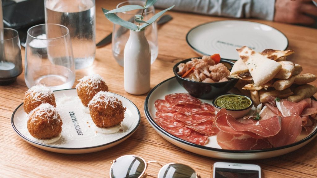 Tapasavond met warme potjes, charcuterie, croquetas en dips op een sfeervol gedekte tafel.
